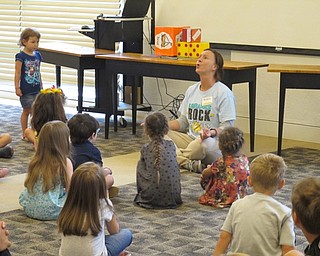 Neighbors | Jessica Harker.Librarian Allison Graf taught children different yoga poses during the June 28 Gotta Move story time at the Austintown library.
