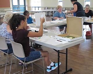 Neighbors | Jessica Harker .Participants practice decorating bubble cookies with blue and white royal icing on June 26 at the beginners cookie decorating class.