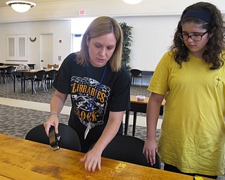 Neighbors | Natalie Wright.Librarian Lyndsay Cramer showed a participant how to use the pick punch to make guitar picks. The participant said that one of her hobbies is playing the guitar.