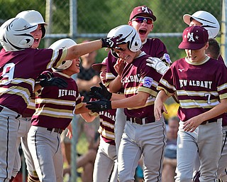 NORTH CANTON, OHIO - JULY 26, 2018: New Albany's Ben Liebel is mobbed by his teammates after hitting a solo home run off Boardman starting pitcher Gavin Hyde in the fourth inning of a Little League baseball game, Thursday night in North Canton. New Albany won 3-1. DAVID DERMER | THE VINDICATOR