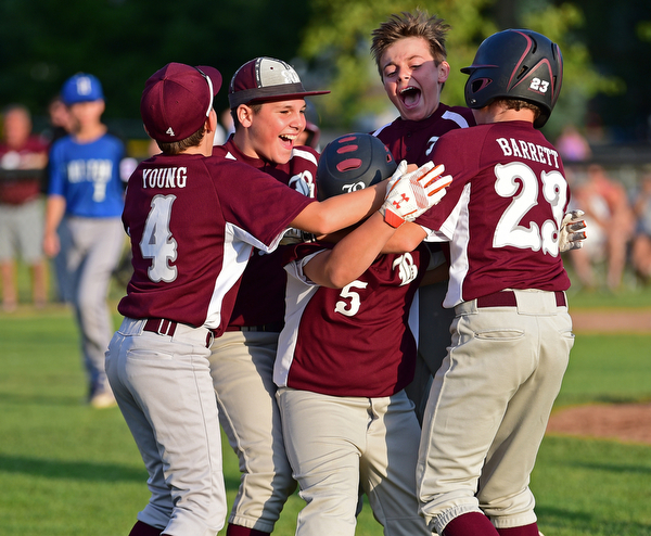 NORTH CANTON, OHIO - JULY 17, 2018: Boardman's Tyler Kirlik, center, is mobbed by his teammates including Dylan Barrrett, Charlie Young, Zach Ganser and Marty Stachowicz after hitting a walk off single with the bases loaded to beat Hamilton 5-4 in the sixth inning of a Little League baseball game, Friday night in North Canton. DAVID DERMER | THE VINDICATOR