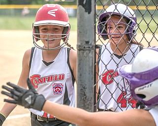 Canfield's Sam Economous, left, and Riley Billak, center, are all smiles returning to the dugout after scoring and are congratulated by teammate Brooke Opalick during 10-U state tournament action in Tallmadge on Monday. Canfield won 18-4 against Austintown.