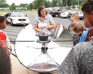 Jennifer Gasser of Hubbard, one of the Solar Sisters, explains how a parabolic solar cooker works to Paul C. Bunn Elementary School summer school students in Youngstown.