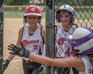 DIANNA OATRIDGE | THE VINDICATOR Canfield's Sam Economous (left) and Riley Billak (center) are all smiles returning to the dugout after scoring and are congratulated by teammate Brooke O'Palick (right) during 10 U state tournament action in Tallmadge on Monday. Canfield won 18-4.