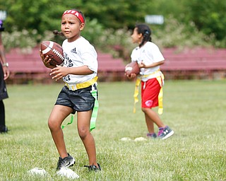 Aliyah Giles, 6, of Boardman, practices techniques for holding a football while running at the Grrridiron Girls Flag Football Camp at Glacier Field in Struthers on Tuesday. EMILY MATTHEWS | THE VINDICATOR