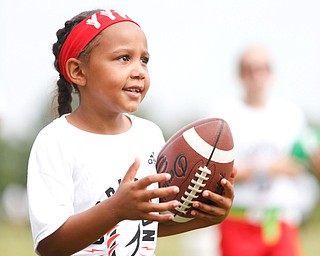 Aliyah Giles, 6, of Boardman, practices techniques for holding a football while running at the Grrridiron Girls Flag Football Camp at Glacier Field in Struthers on Tuesday. EMILY MATTHEWS | THE VINDICATOR