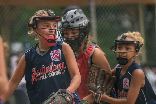 DIANNA OATRIDGE | THE VINDICATOR Austintown's Sam Severn (left), Kylie Folkwein (center), and Kali Ray (right) celebrate as they return to the dugout after a good defensive stand during the loser's bracket final of the 9-10 Little League state tournament in Tallmadge. Austintown lost 7-3.