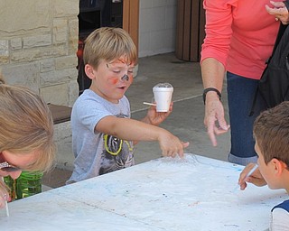Neighbors | Jessica Harker.Logan Naughton popped bubbles that he blew directly onto the table using a straw at the July 6 Family Fun Friday event at Fellows Riverside Garden.
