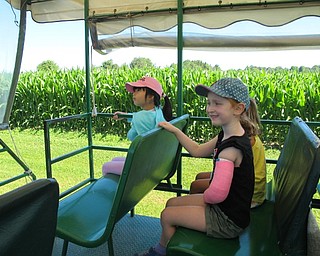 Neighbors | Jessica Harker.Amy Zhana (front) along with Riley Pieren (back) listen as the insturctor explained different animal and plant facts during a tractor tour of the MetroParks farms on July 9.