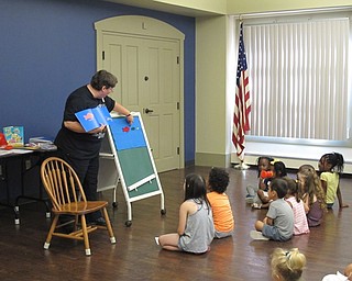 Neighbors | Jessica Harker.Karen Saunders, the childrens librarian at Boardman library, uses magnetic fish on a chalk board to read "Blue Sea," to the group of children gathered at the Family Story time July 11.