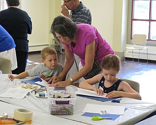 Neighbors | Jessica Harker.Lindd Holloway helped her two grandchildren, Luke, age 4, and Phoebe, age 7, create nets out of paper for the project portion of Family Story time July 11 at Boardman park.