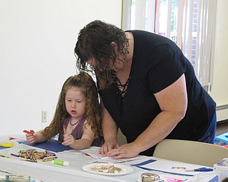 Neighbors | Jessica Harker.Shelli Smith helps her daughter, Elizabeth, age 3, create a net out of paper for the project portion of Family Story time at the Boardman library July 11.