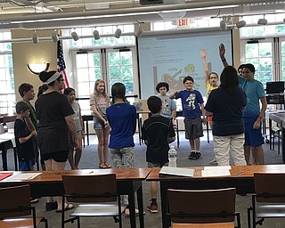 Neighbors | Jessica Harker.Children gathered in a circle to play at game during the ASL camp at the Poland library July 26.