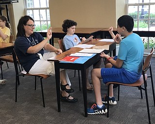 Neighbors | Jessica Harker.Librarian Karen Steed practiced signing her name with students on July 26 at the first ASL camp at the Poland library.