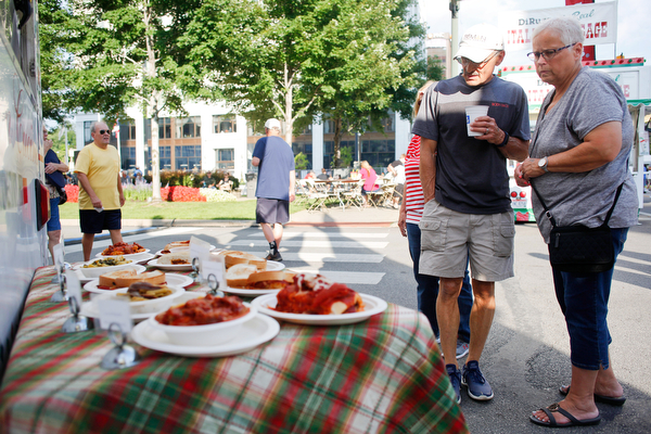 Joe and Billie Marscio, both of Warren, look at some of the food being sold by Roberto's Italian Ristorante at the Greater Youngstown Italian Fest on Friday. EMILY MATTHEWS | THE VINDICATOR