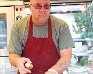 Daniel Blystone, of Canfield, looks up from sorting cannolis at the Greater Youngstown Italian Fest on Friday. EMILY MATTHEWS | THE VINDICATOR