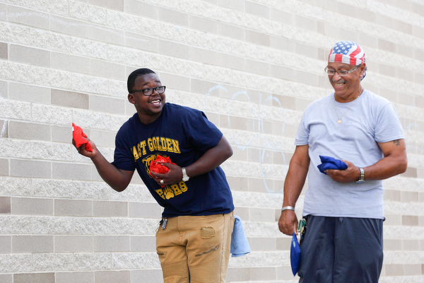 Gene Kelly, left, who went to Boardman high school and who's mother graduated from East High School in 1976, plays corn hole with Ramon Mercado, class of 1968, at the East High School Alumni Reunion on Saturday.