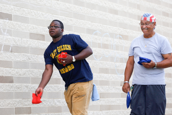 Gene Kelly, left, who went to Boardman high school and who's mother graduated from East High School in 1976, plays corn hole with Ramon Mercado, class of 1968, at the East High School Alumni Reunion on Saturday.
