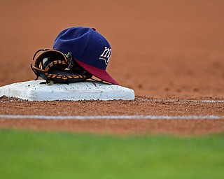 NILES, OHIO - AUGUST 6, 2018: A Mahoning Valley Scrappers hat and glove rest on first base in the second inning of a baseball game, Monday night at Eastwood Field in Niles. DAVID DERMER | THE VINDICATOR