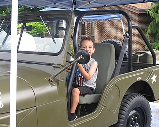 Neighbors | Jessica Harker.Michael Cardona posed in an Army jeep brought by the DAV to the Austintown Farmers Market on July 2.