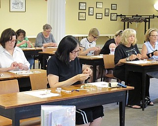 Neighbors | Jessica Harker .Lark Cocco strung beads onto metal wire to create her lava stone necklace July 10 at the Poland library.