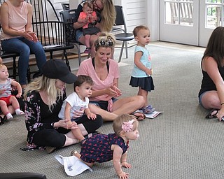 Neighbors | Jessica Harker.Children and their guardians listen to librarian Amanda Kollar during the Baby Brilliant event at the Poland library July 25.