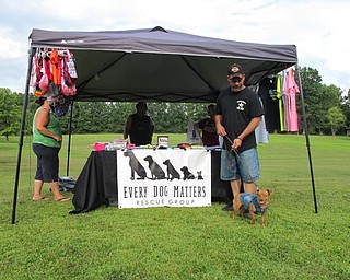 Neighbors | Jessica Harker.Jeff Liscic stood in front of the Every Dog Matters rescue group's stand with his dog Chico, who was wearing one of the stand's items, a denim vest.