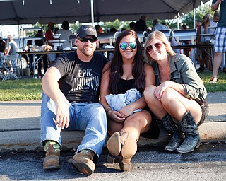 From left, Mark Cramer, of Liberty, Kelly Hyde, of Girard, and Carly Cramer, of Liberty, sit in the tailgating parking lot before the Florida Georgia Line concert on Saturday. EMILY MATTHEWS | THE VINDICATOR