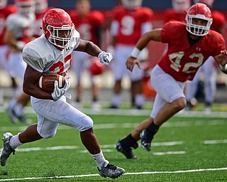 AUSTINTOWN, OHIO - AUGUST 11, 2018: Youngstown State's Tevin McCaster, white, runs the ball away from Armand Dellovade, red, during the teams practice, Saturday morning at Austintown Fitch High School. DAVID DERMER | THE VINDICATOR