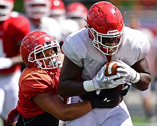 AUSTINTOWN, OHIO - AUGUST 11, 2018: Youngstown State's Charles Reeves Jr., white, fights for yards while being tackled by Curtis Parks during the teams practice, Saturday morning at Austintown Fitch High School. He would score on the play. DAVID DERMER | THE VINDICATOR