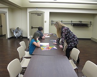 Neighbors | Natalie Wright.Librarian Amy Burkard helped a participant decide where to start her Paint by Sticker project at the Boardman library. Images of music icons were featured at this event.