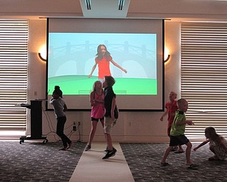 Neighbors | Jessica Harker.Children jump along with a video played at the Gotta Move 2.0 event at the Austintown library.