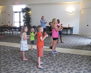 Neighbors | Jessica Harker.Librarian Allison Graf, along with the group of children gathered, tried to copy the movements of a youtube video played at the Gotta Move 2.0 event on July 27.