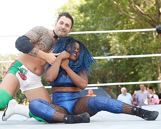 Wrestler Mambo Italiano puts his opponent Joseline Navarro in a headlock at the Latino Heritage Festival in Campbell on Saturday. EMILY MATTHEWS | THE VINDICATOR