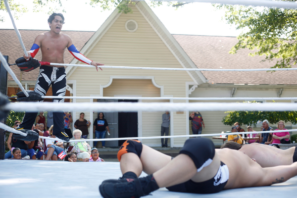 Wrestler Marc-Anthony Alejandro, left, cheers for his teammate Calvin Couture as he wrestles Dan Hooven at the Latino Heritage Festival in Campbell on Saturday. EMILY MATTHEWS | THE VINDICATOR