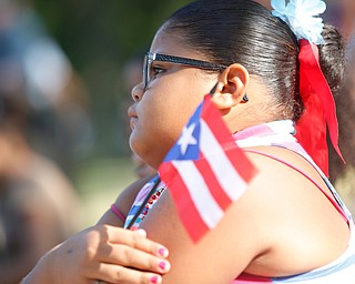 Jodairys Vasquez, 9, of Campbell, holds a Puerto Rican flag while watching wrestling at the Latino Heritage Festival in Campbell on Saturday. EMILY MATTHEWS | THE VINDICATOR