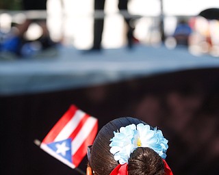 Jodairys Vasquez, 9, of Campbell, waves a Puerto Rican flag while watching wrestling at the Latino Heritage Festival in Campbell on Saturday. EMILY MATTHEWS | THE VINDICATOR