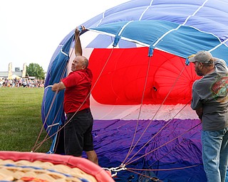 Rick Kohut, left, a hot air balloon pilot, and Chuck Evans, of Austintown, inflate a hot air balloon at the Hot air balloon festival at Mastropietro Winery on Sunday..