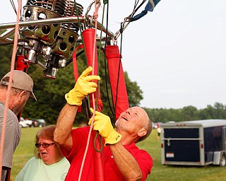 Rick Kohut, right, a hot air balloon pilot, gets his hot air balloon ready while Chuck Evans and Debbie Evans, both of Austintown, get in the basket at the Hot air balloon festival at Mastropietro Winery on Sunday. It was the Evans's 40th wedding anniversary..