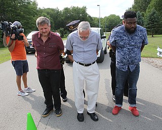  ROBERT K.YOSAY  | THE VINDICATOR..In the spirit of the afternoon, Akron-Canton area residents John Beaty, Austin Miller, Dustin White, James Talbert and JR Rozco prepared for their arrest with a song...After three hours of protest chants, the five clergy members stood at the entrance of the Northeast Ohio Correctional Center on Youngstown-Hubbard Road on Monday with their arms around each other and sang ÒNearer, My God, To TheeÓ Ð the hymn associated with the sinking of the Titanic....-30-