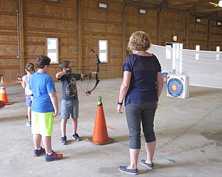 Neighbors | Jessica Harker .Instructor Robin Adams helped children as they prepared to shoot their arrows at designated targets on July 24.