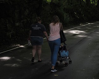 Neighbors | Jessica Harker.Park employee Cody Stoll and Tara Calco, pushing her daughter Theresa, walked in Mill Creek Park for the bi-monthly Trot With Your Tot event.