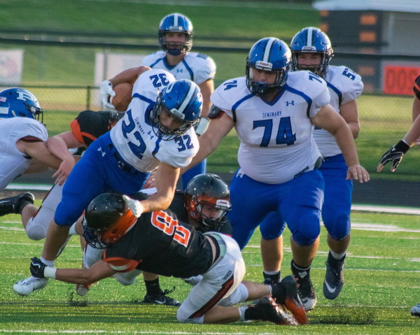 Poland running back Jake Rutana is brought down by a Marlington defender as teammate Jared Carcelli looks on in the BulldogsÕ 17-14 win Thursday night in Alliance...BOB ETTINGER | THE VINDICATOR
