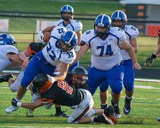 Poland running back Jake Rutana is brought down by a Marlington defender as teammate Jared Carcelli looks on in the BulldogsÕ 17-14 win Thursday night in Alliance...BOB ETTINGER | THE VINDICATOR