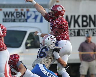 Jakob Cross (5) of Columbiana throws the ball away as he is being brought down by Jimmy Mayberry (16) of Western Reserve during Thursday night's matchup at Firestone Park in Columbiana. Dustin Livesay  |  The Vindicator  8/23/18  Columbiana