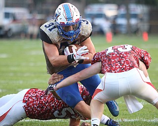 Adam Gatrell (31) of Western Reserve lowers his shoulder to fight through a tackle attempt by Columbiana's Thurston Burt (13) and Erik Hopfenziz (52) during Thursday night's matchup at Firestone Park in Columbiana. Dustin Livesay  |  The Vindicator  8/23/18  Columbiana