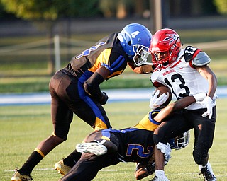 Campbell's Daquan Bebbs gets tackled by Valley Christian's Damon Christian (2) Tyrone Lindsey (4)runs the ball past Campbell's Jake Armeni during the first half of their game Saturday night at Dave Pavlansky Field in Poland. EMILY MATTHEWS | THE VINDICATOR