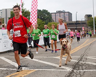 Dan Liptak, of Boardman, crosses the finish line with his golden doodle Charlie after running the 2-mile race at Panerathon outside of Covelli Centre on Sunday. .EMILY MATTHEWS | THE VINDICATOR