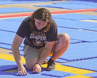  ROBERT K.YOSAY  | THE VINDICATOR..Alex Roessler - Youth and Amateur Hockey Development .places plastic DEK ..Mill Creek ParkÕs old ice skating rink is getting a blue makeover courtesy of a team that wears black and gold..On Tuesday morning, volunteers from Mill Creek MetroParks, Home Savings and Loan, the Youngstown Phantoms and The Pittsburgh Penguins Foundation were laying down blue tiles for the ParkÕs new dek hockey rink