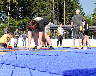  ROBERT K.YOSAY  | THE VINDICATOR..Mill Creek ParkÕs old ice skating rink is getting a blue makeover courtesy of a team that wears black and gold..On Tuesday morning, volunteers from Mill Creek MetroParks, Home Savings and Loan, the Youngstown Phantoms and The Pittsburgh Penguins Foundation were laying down blue tiles for the ParkÕs new dek hockey rink